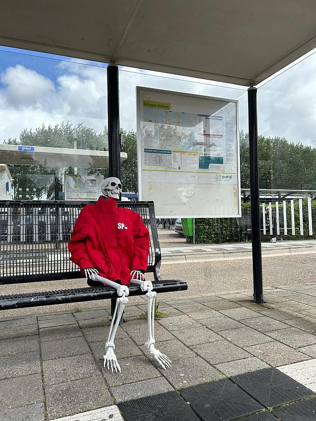 skelet wachtend bij de bushalte op de bus die niet meer komt